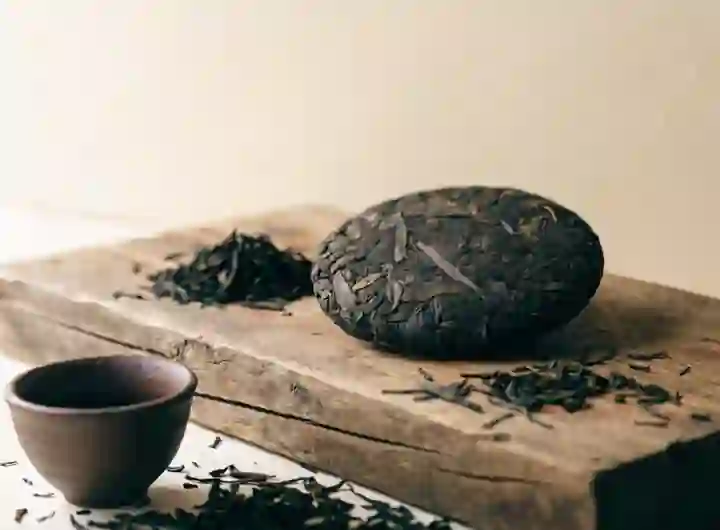 Prasowany placek ciemnej herbaty pu-erh na drewnianej desce
